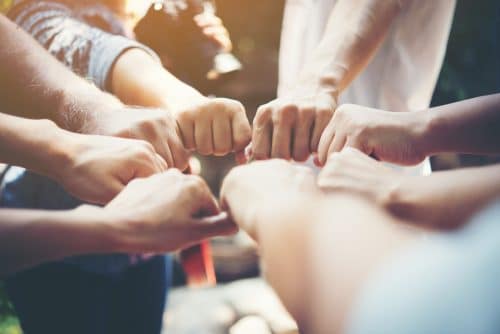 Personnes faisant un geste de solidarité.